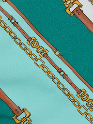 Nicole Bikini Bottom in a patterned fabric with teal and light blue stripes, featuring a belt-stripe print accented by brown leather straps and gold chains running diagonally across the surface.