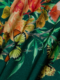 A close-up of the Remi One-Piece Swimsuit, showcasing green fabric adorned with a vibrant floral-butterfly print featuring yellow and orange flowers, lush green leaves, and a pale yellow butterfly with striking black accents.