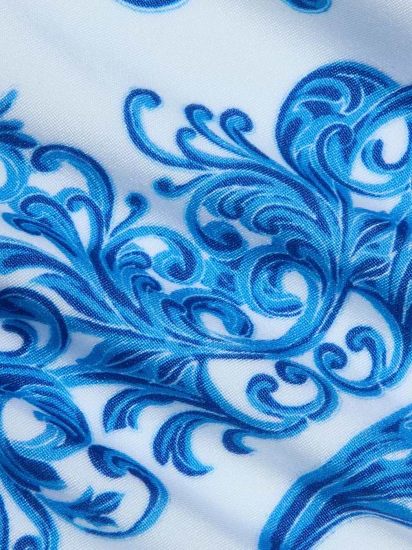Close-up of the Gianna Brazilian Bikini Bottom's white fabric featuring an intricate blue baroque print with swirling florals and vines for a detailed, decorative look.