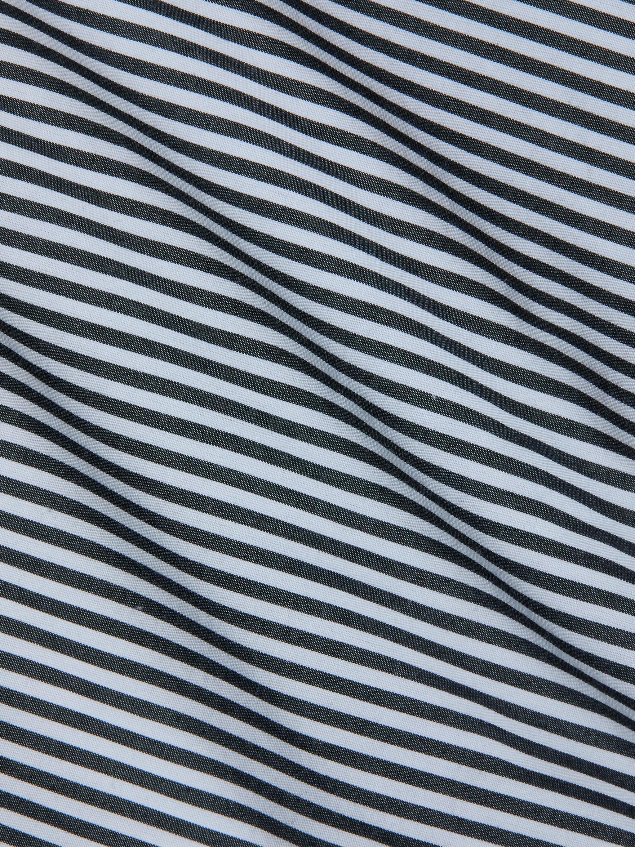 Close-up of fabric with diagonal black and white stripes, featuring a smooth texture and gentle folds—an ideal match for the Amiya Cover-Up Short, perfect for resort dressing.