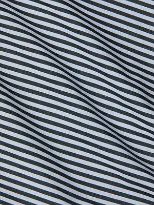 Close-up of the Amiya Cover-Up Short fabric, featuring evenly spaced black and white diagonal stripes in a wavy pattern. The textured surface adds a modern touch, making it ideal for resort dressing.