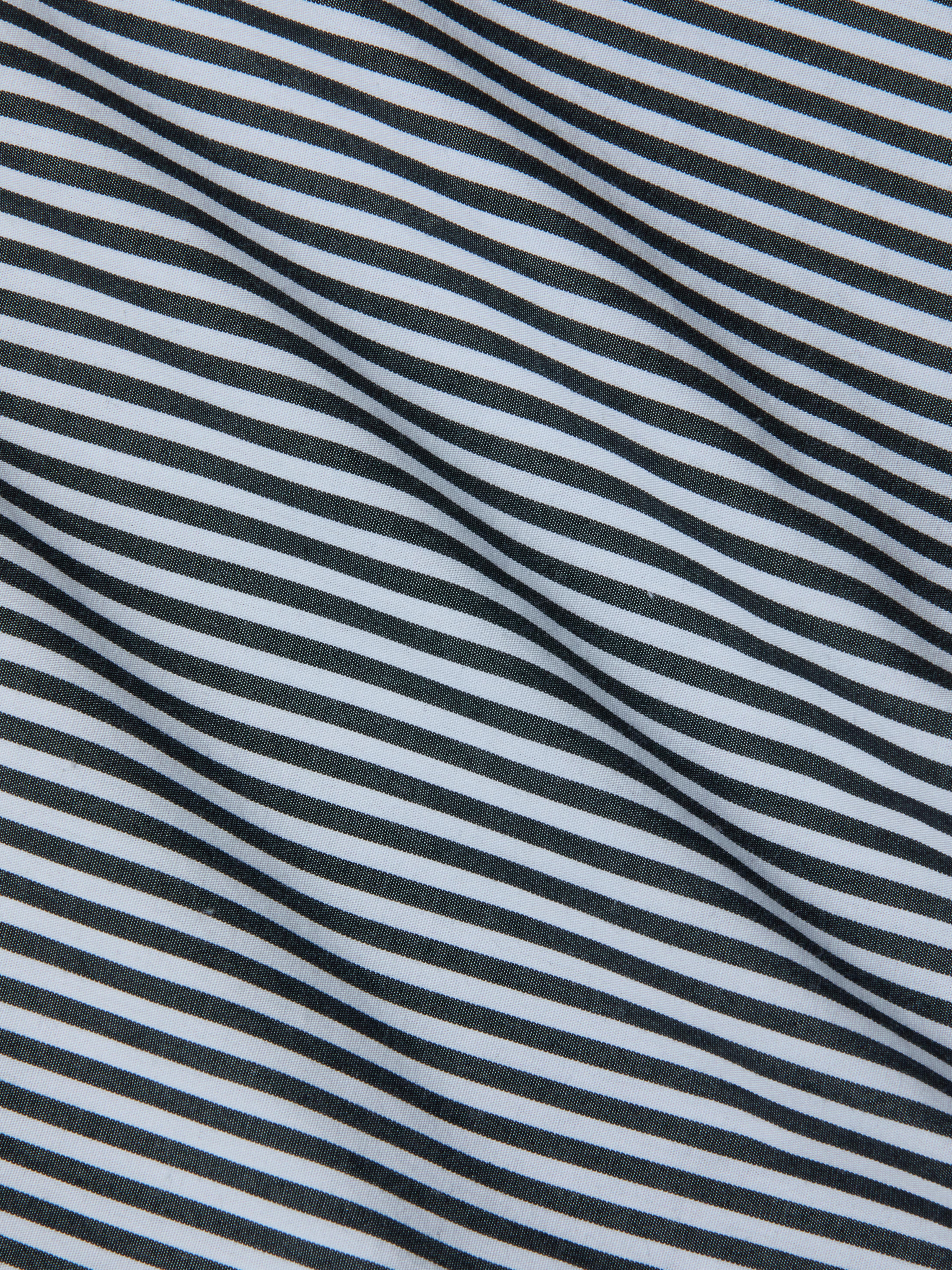Close-up of fabric with diagonal black and white stripes, featuring a smooth texture and gentle folds—an ideal match for the Amiya Cover-Up Short, perfect for resort dressing.