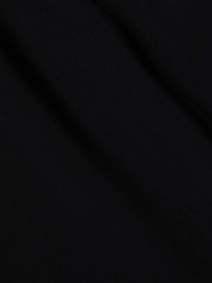 A close-up of the Klaire Cover-Up Skirt by L'AGENCE, crafted from smooth black viscose chiffon, features subtle diagonal folds and shadows that create a soft, elegant texture across the fabric.