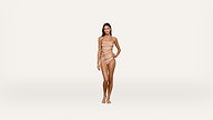A woman stands facing forward, wearing a colorful, striped one-piece swimsuit with cutouts. She stands barefoot against a plain white background.