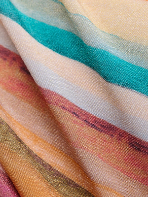 A close-up of the Krysta Halter Bikini Top shows soft, slightly wrinkled fabric with horizontal stripes in teal, peach, white, orange, red, and yellow for a relaxed look.