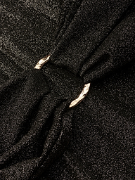 Close-up of the Lisa Plunge One-Piece Swimsuit’s shimmery black fabric, gathered by a shiny silver metal ring that creates soft folds and elegant texture.