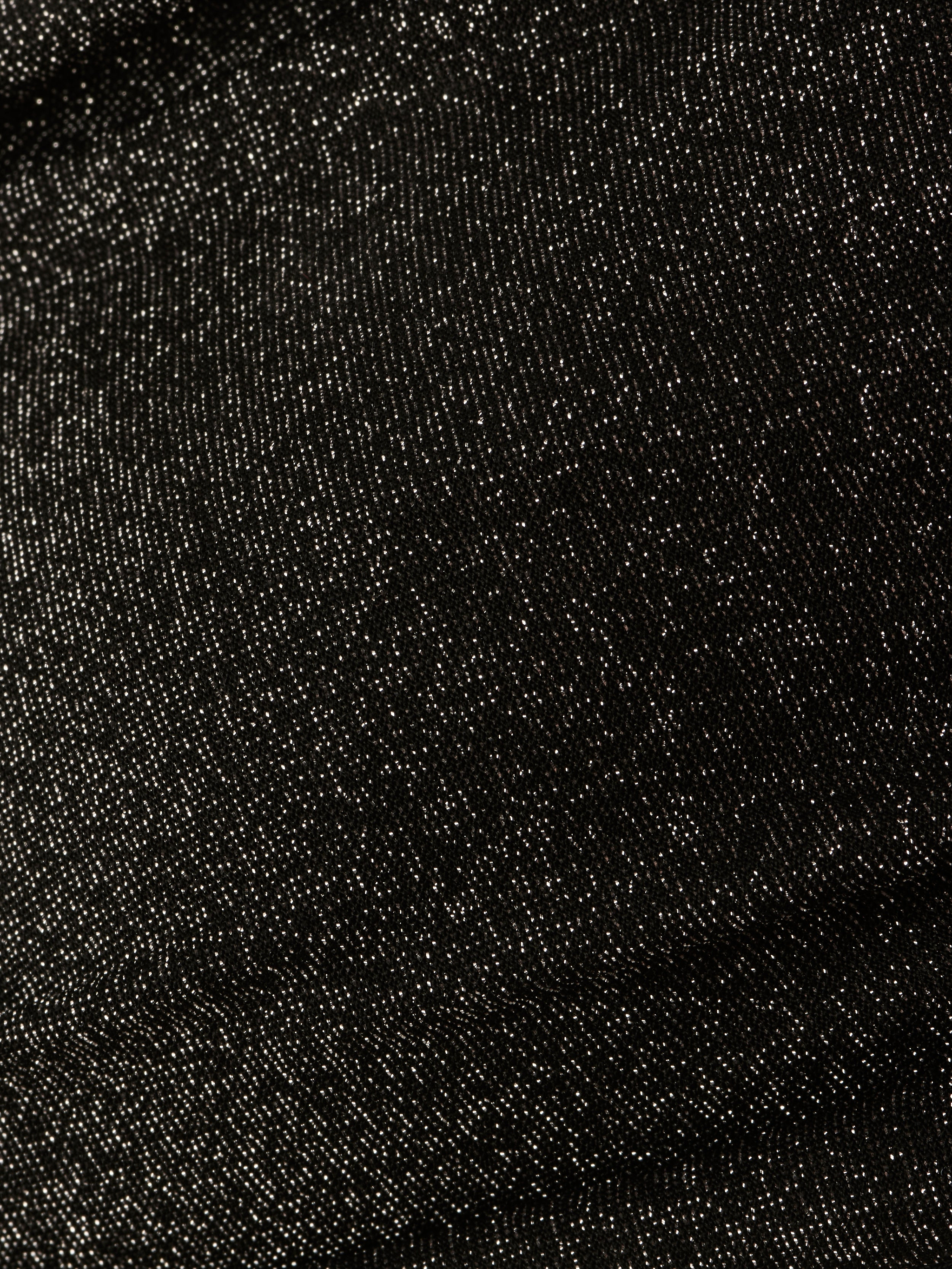 Close-up of the Krysta Halter Bikini Top’s textured black fabric, featuring a subtle sheen and fine weaving patterns reminiscent of metallic black.