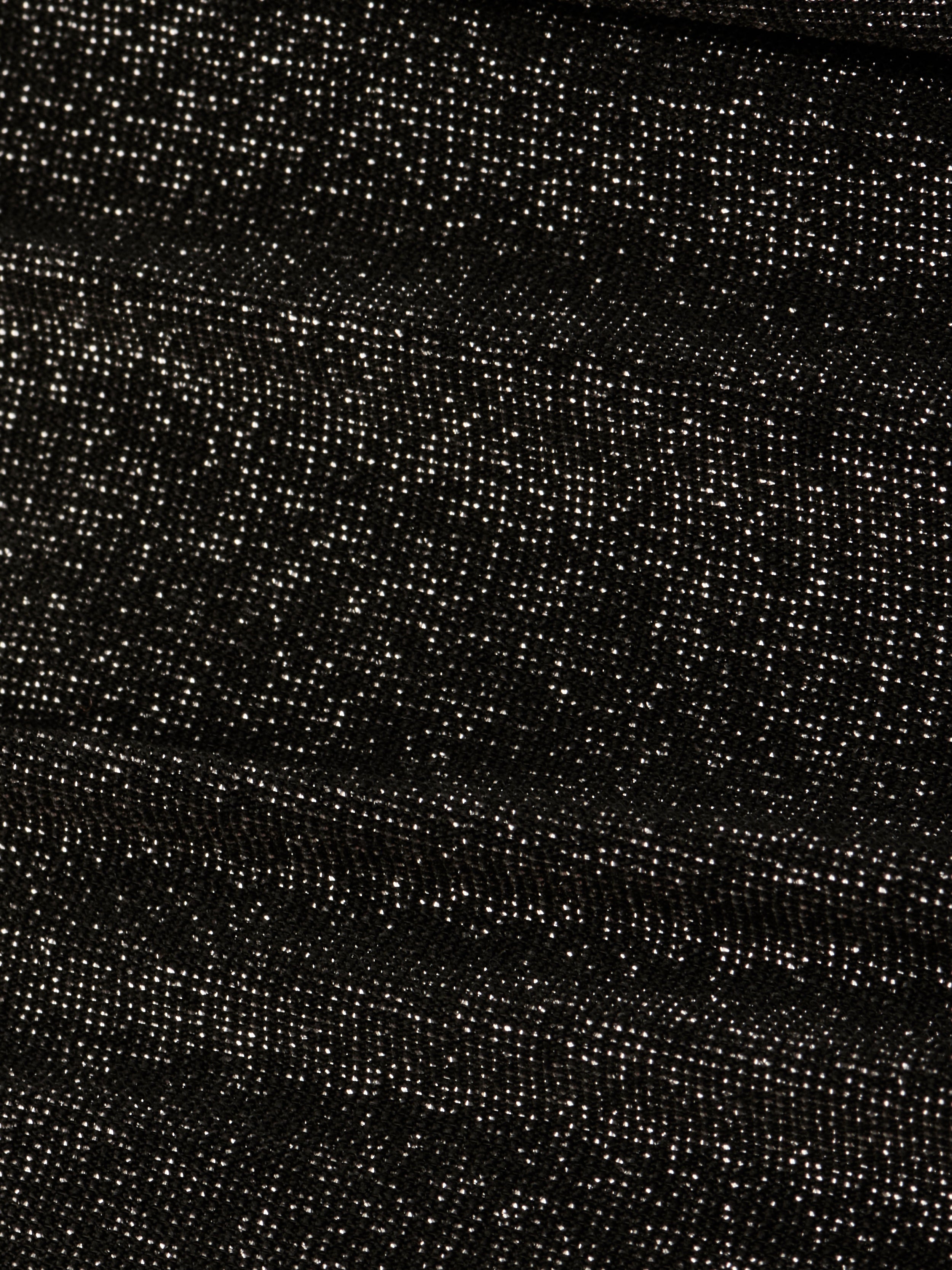 Close-up of the Nicole Bikini Bottom’s textured metallic black fabric, featuring small white specks evenly distributed across the surface for a starry, glittery effect.