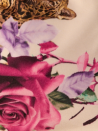 The Annabelle Triangle Bikini Top showcases a jungle leopard print, highlighting the leopard’s face framed by vibrant purple and pink flowers with green leaves on a light background.