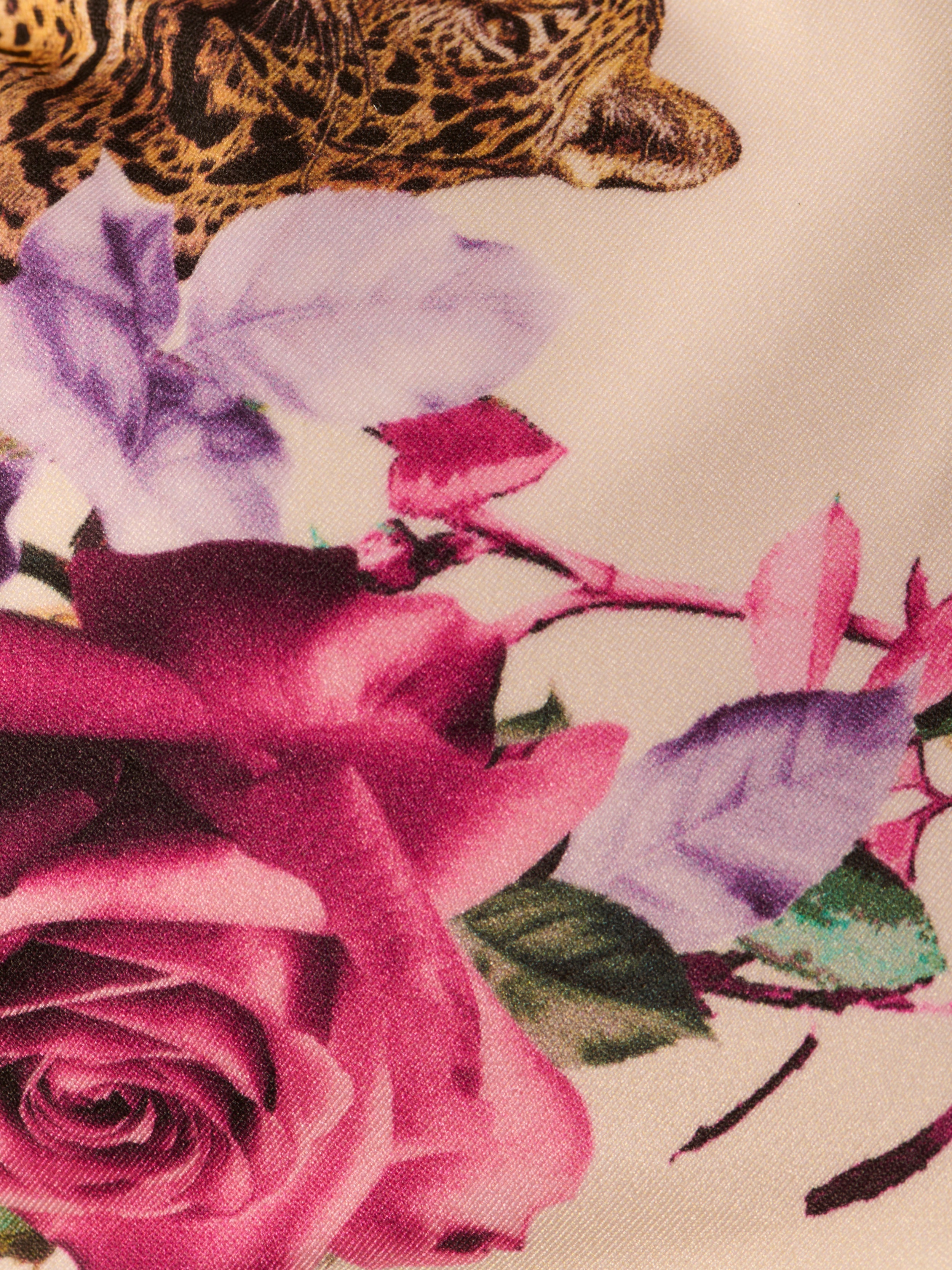 The Annabelle Triangle Bikini Top showcases a jungle leopard print, highlighting the leopard’s face framed by vibrant purple and pink flowers with green leaves on a light background.