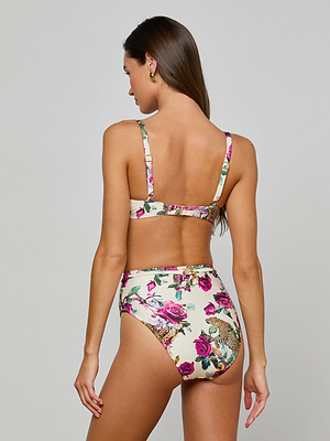 A woman with long brown hair models the Vanessa High-Waisted Bikini Bottom, featuring pink rose leopard print and UPF 50, as she faces away to display the back design against a plain light gray background.