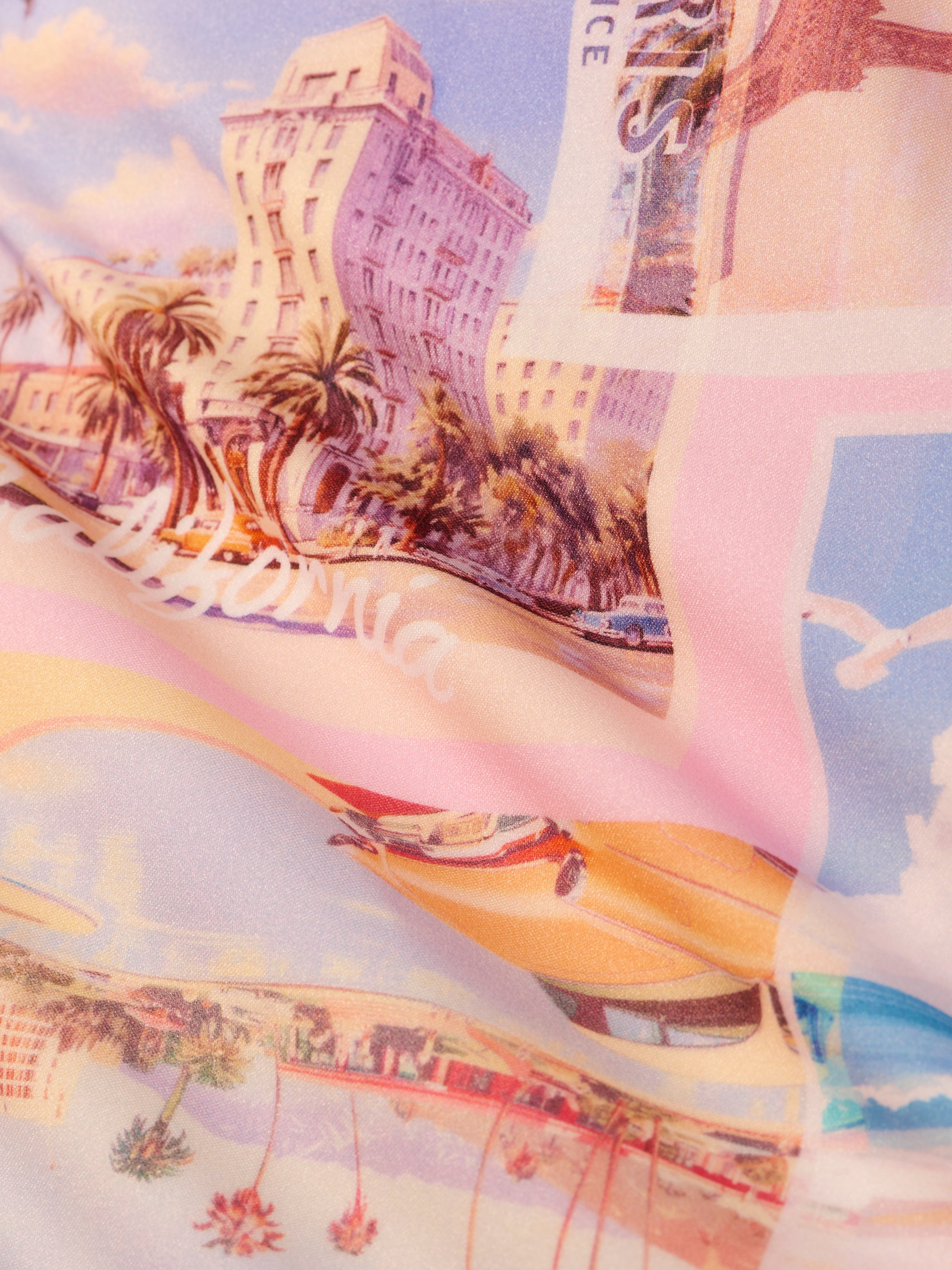 Bright and nostalgic, the Remi One-Piece Swimsuit features a vibrant fabric print of vintage California postcards—palm trees, classic cars, hotels in pastel hues—and chic chain hardware straps for a retro beach vibe.