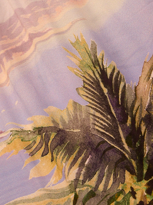 A close-up of the Enyo Cover-Up Short fabric, showcasing a postcard print with green palm leaves and a pastel sky in purple, pink, and yellow.