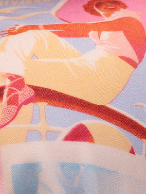 A colorful, vintage-style illustration of a woman in the Kristin Triangle Bikini Top and light pants, sitting with legs crossed. The image features pink, yellow, and blue tones with a soft, textured effect.