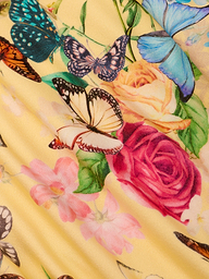 A close-up of colorful butterflies and vibrant flowers, including roses, printed on pleated yellow fabric—perfect for the Jean Bikini Bottom with a high-leg, low-rise cut.