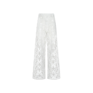 The Geraldine Cover-Up Pant is a white lace, high-waisted wide-leg pant showcasing a sheer floral pattern and subtle bohemian inspiration. Delicate and elegant, these pants are displayed against a plain white background.