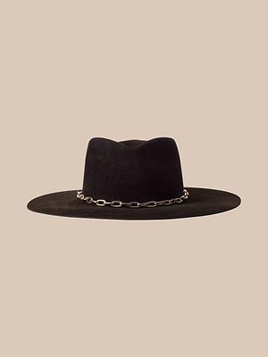 Il cappello Umbra è un cappello di feltro marrone scuro a tesa larga con una fascia a catena dorata intorno alla corona, raffigurato su uno sfondo beige.