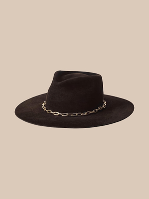 Il cappello Umbra è un cappello in feltro marrone a tesa larga, realizzato a mano, caratterizzato da una catena dorata che ne impreziosisce la corona, raffigurato su uno sfondo beige a tinta unita.