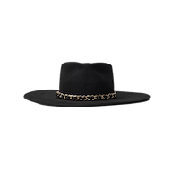 Ferrante Hat by Gladys Tamez Millinery—a wide-brimmed black felt design highlighted by a striking gold chain band around the base of the crown, showcased against a plain white background.