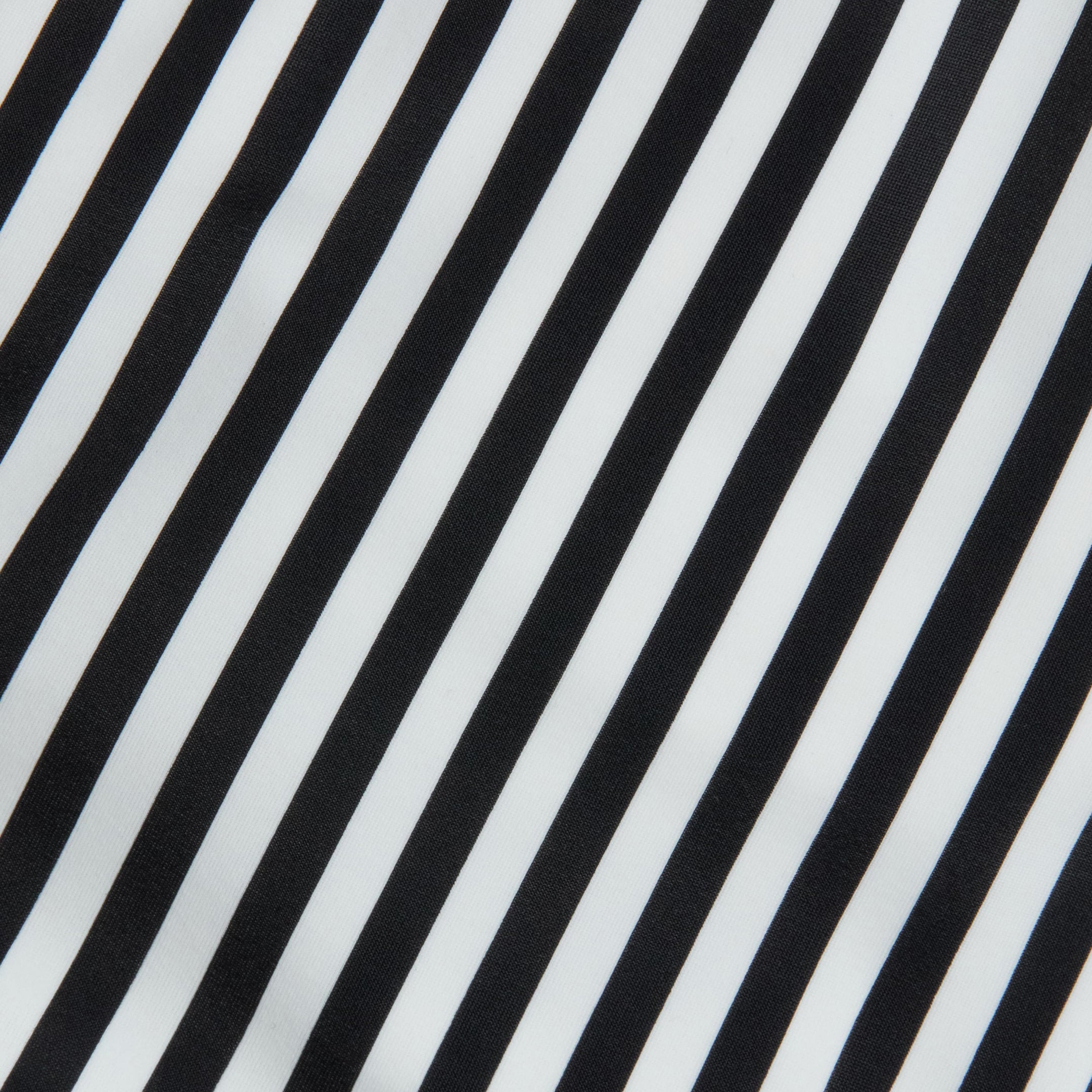 Diagonal black-and-white stripes on a smooth fabric capture the timeless elegance of French glamour, forming a bold yet minimalist pattern inspired by the Leila Halter One-Piece Swimsuit.