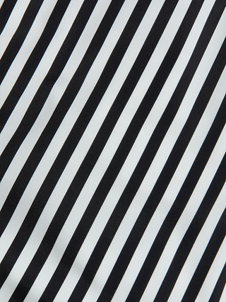 Diagonal black and white stripes form a bold, high-contrast pattern across the Leila Halter One-Piece Swimsuit, creating a visually striking and repetitive design that makes a statement both in and out of the water.