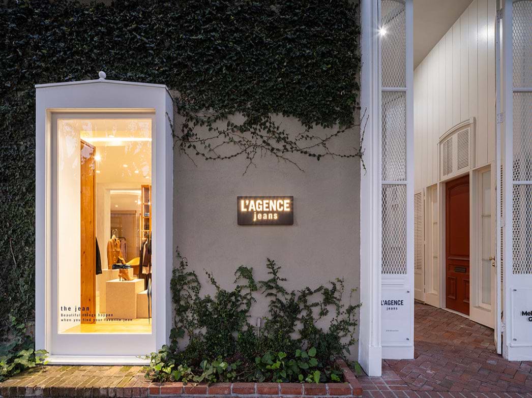 Modern building entrance with 'L'AGENCE' sign and illuminated interior.