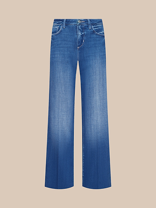 The Petite Scottie Wide-Leg Jean from the Les Petites Collection is shown in a soft indigo wash with a faded finish, front pockets, belt loops, and a button waistband, displayed on a beige background.
