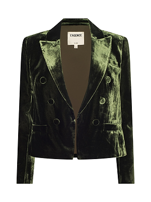 The Brooke Velvet Blazer by L'AGENCE is a dark green, silk-infused velvet double-breasted blazer with wide lapels, long sleeves, and four fabric-covered buttons on each side. The L'AGENCE label appears inside the collar.