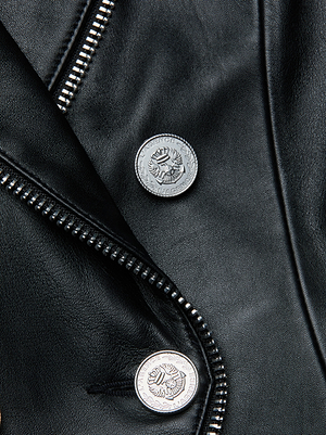 Close-up of the Ottilie Leather Blazer by L'AGENCE in Italian lambskin, featuring a smooth, slightly glossy finish, silver crest-engraved buttons, and a metal zipper—perfect for power dressing sophistication.
