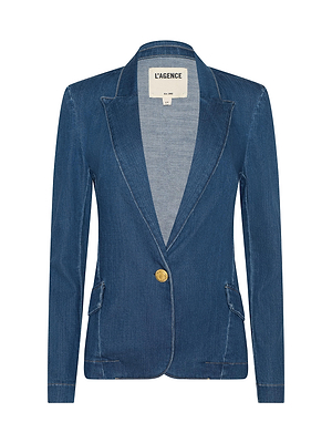 The Baldwin Blazer by L’AGENCE is a single-breasted indigo stretch denim blazer with notched lapel, gold button closure, two front flap pockets, long sleeves, visible stitching, and an interior L’AGENCE label.