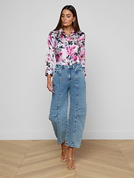 Woman standing against a white background, wearing a floral long-sleeve shirt, the Reba Rodeo Jean—high rise, all-cotton denim with a barrel-leg silhouette—and beige heeled sandals.