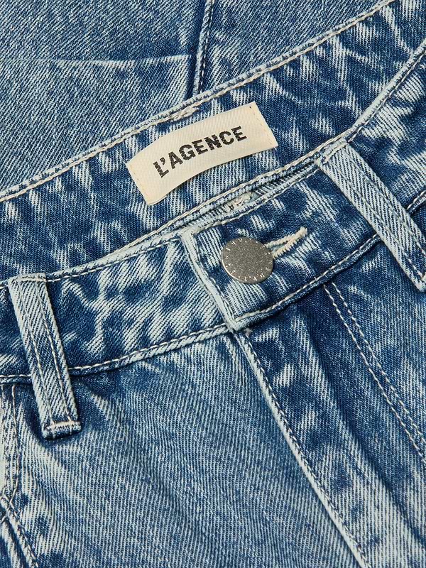 Close-up of the Reba Rodeo Jean, featuring high-rise all-cotton denim with a faded, textured pattern, a silver button, and a white LAGENCE fabric label sewn inside the waistband.