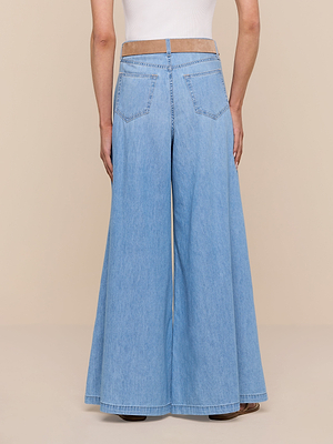 A person is shown from the back against a plain beige background, wearing the Dariela Wide-Leg Jean in light blue featherweight denim and a white sleeveless top.