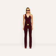 A woman wears a burgundy stretch corduroy vest and matching Saffia Corduroy Pant, a high-rise, slim-straight style featuring a gold-buckled belt.