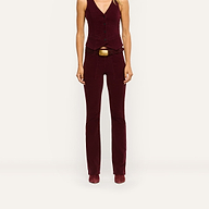 A person wears high-rise burgundy stretch corduroy Saffia Corduroy Pant with a matching button-front vest and a wide brown belt with a large gold buckle.