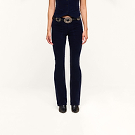 A person wearing the Saffia Corduroy Pant in dark blue, paired with a matching vest, wide belt, and black shoes stands against a plain white background. Their face is not visible.