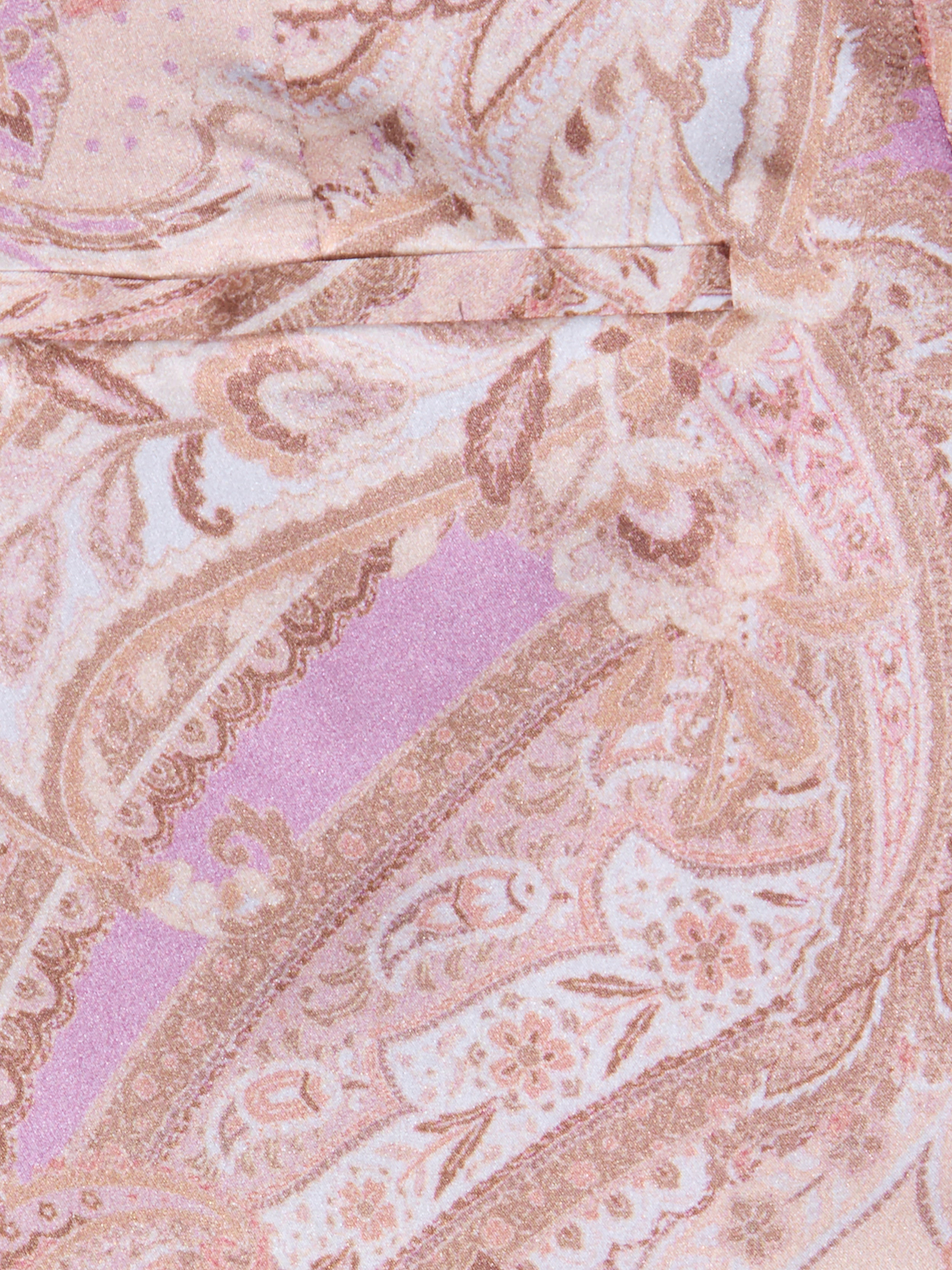 Gros plan sur un tissu à imprimé cachemire rose, lavande et beige avec des tourbillons et des motifs floraux, idéal pour le pantalon large en soie Pilar, qui confère à ce pantalon taille haute une allure douce et élégante.