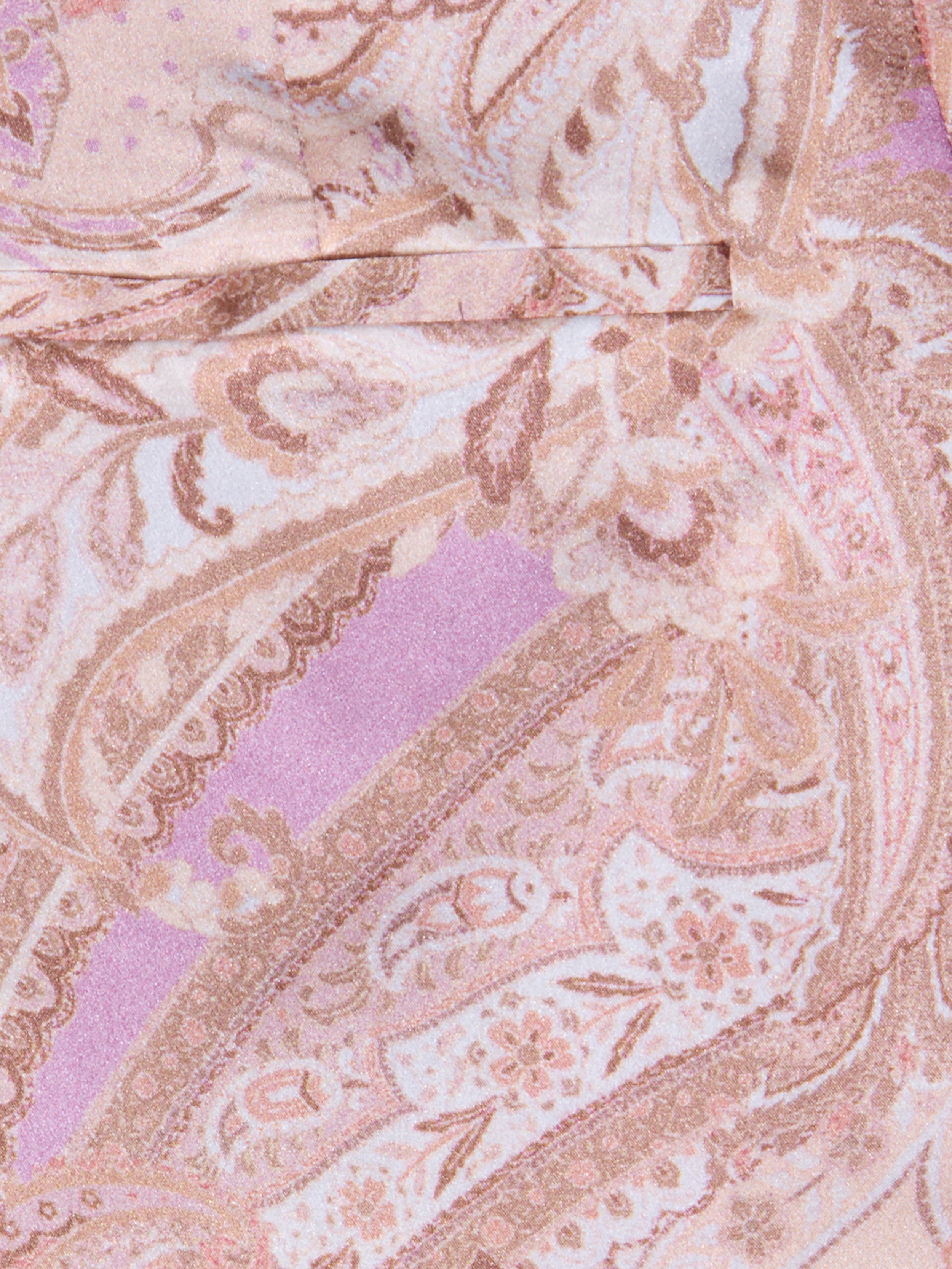Gros plan sur un tissu à imprimé cachemire rose, lavande et beige avec des tourbillons et des motifs floraux, idéal pour le pantalon large en soie Pilar, qui confère à ce pantalon taille haute une allure douce et élégante.