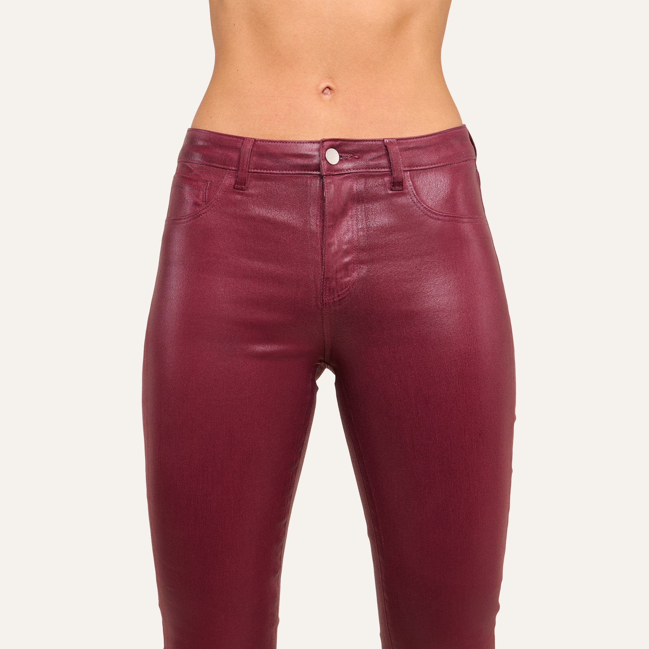 A person wearing high-rise burgundy Selma Coated Bootcut Jean.