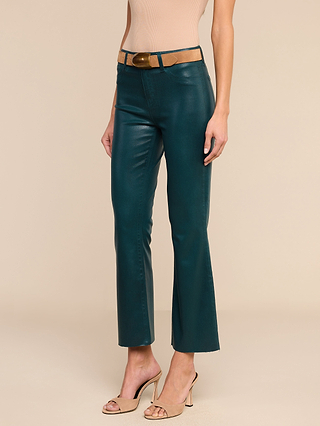 A woman wearing the Kendra Coated Cropped Flare Jean in teal with a tan belt, a sleeveless beige top, and beige open-toe heels stands against a plain beige background.