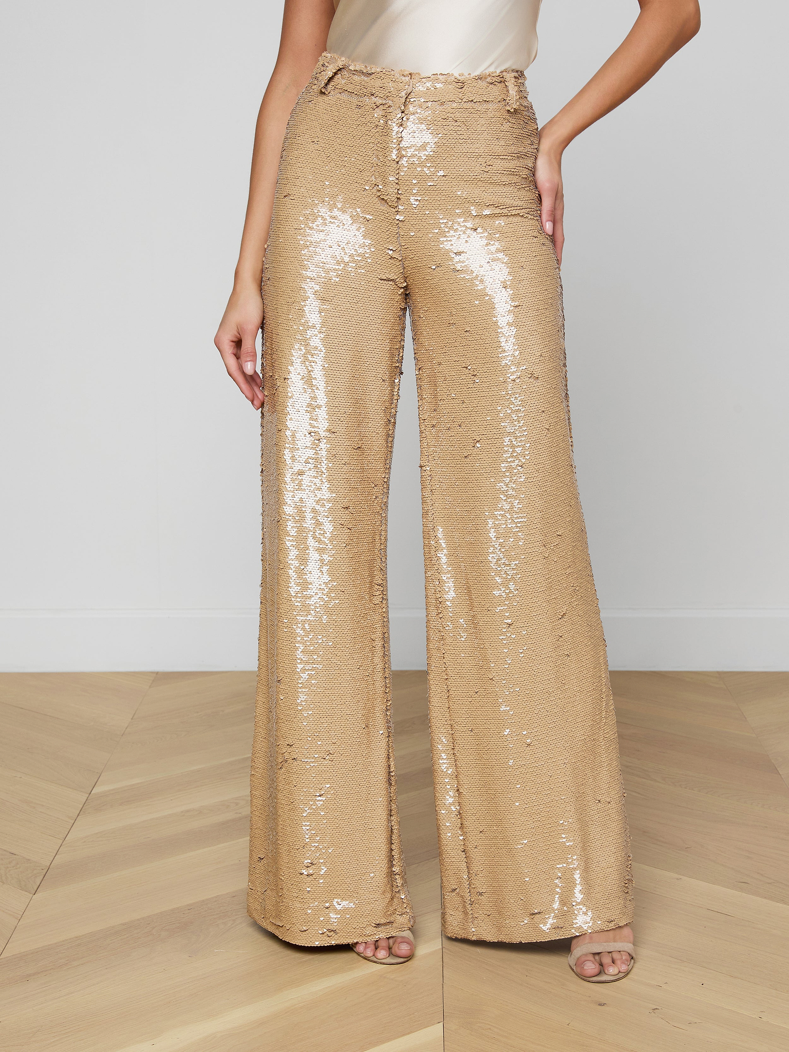 Wearing the Gavin Sequin Wide-Leg Pant, a white top, and open-toed heels, the person stands against a plain light background.