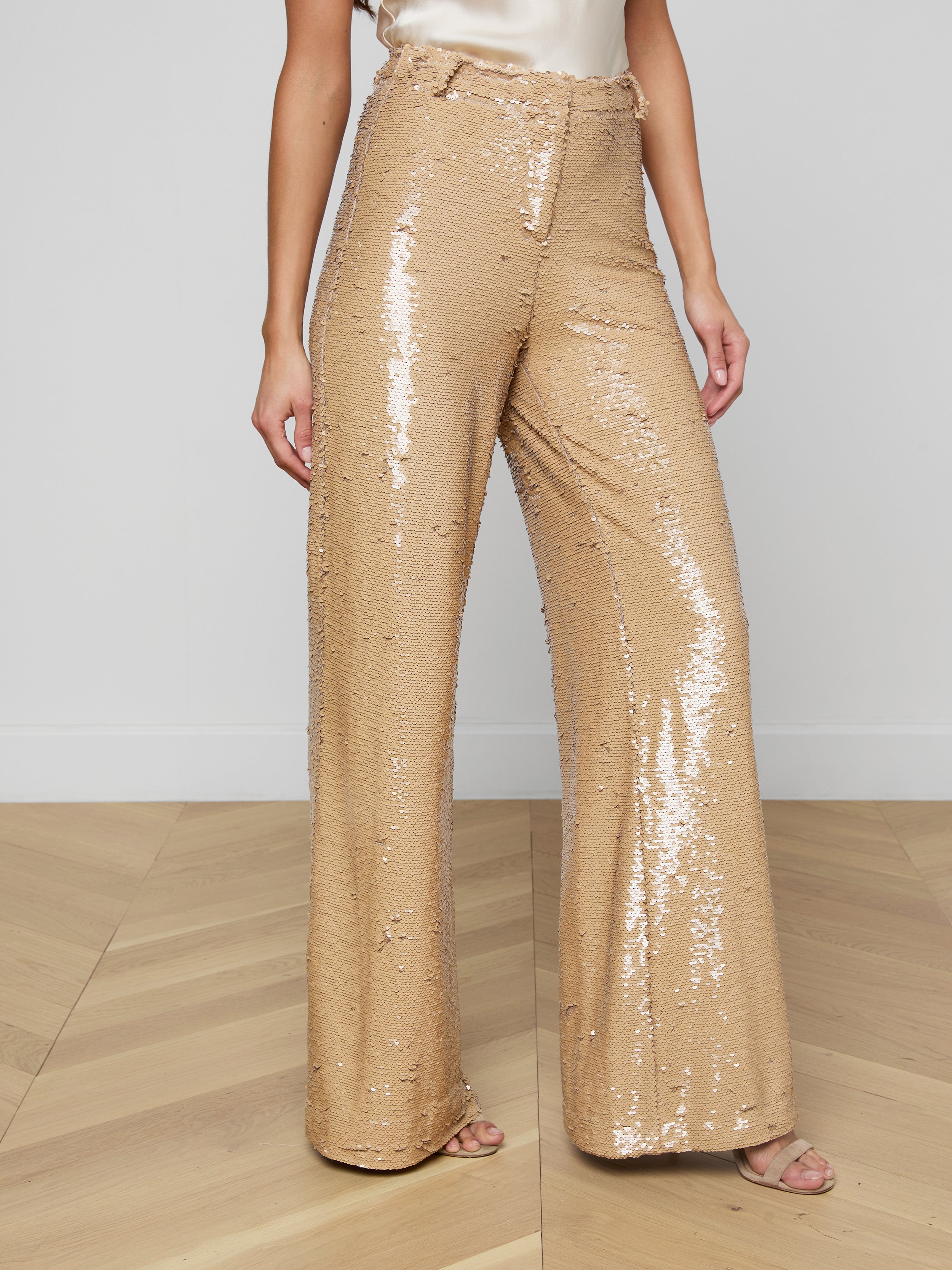 A person wearing the Gavin Sequin Wide-Leg Pant, paired with a light-colored satin top and open-toe heels, stands against a plain background.