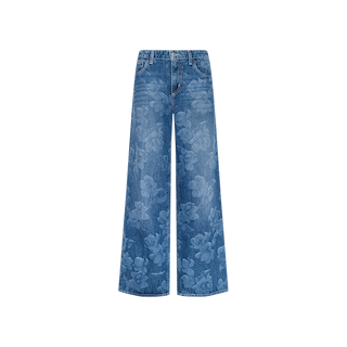 The Alicent Wide-Leg Jean features a subtle floral print across blue denim, designed in a sneaker-length cut and displayed against a plain white background.