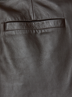 Close-up of the Livvy Leather Trouser by L'AGENCE in chocolate, showcasing textured leather and a welt pocket—perfect for creating sleek straight-leg pants with detailed stitching.