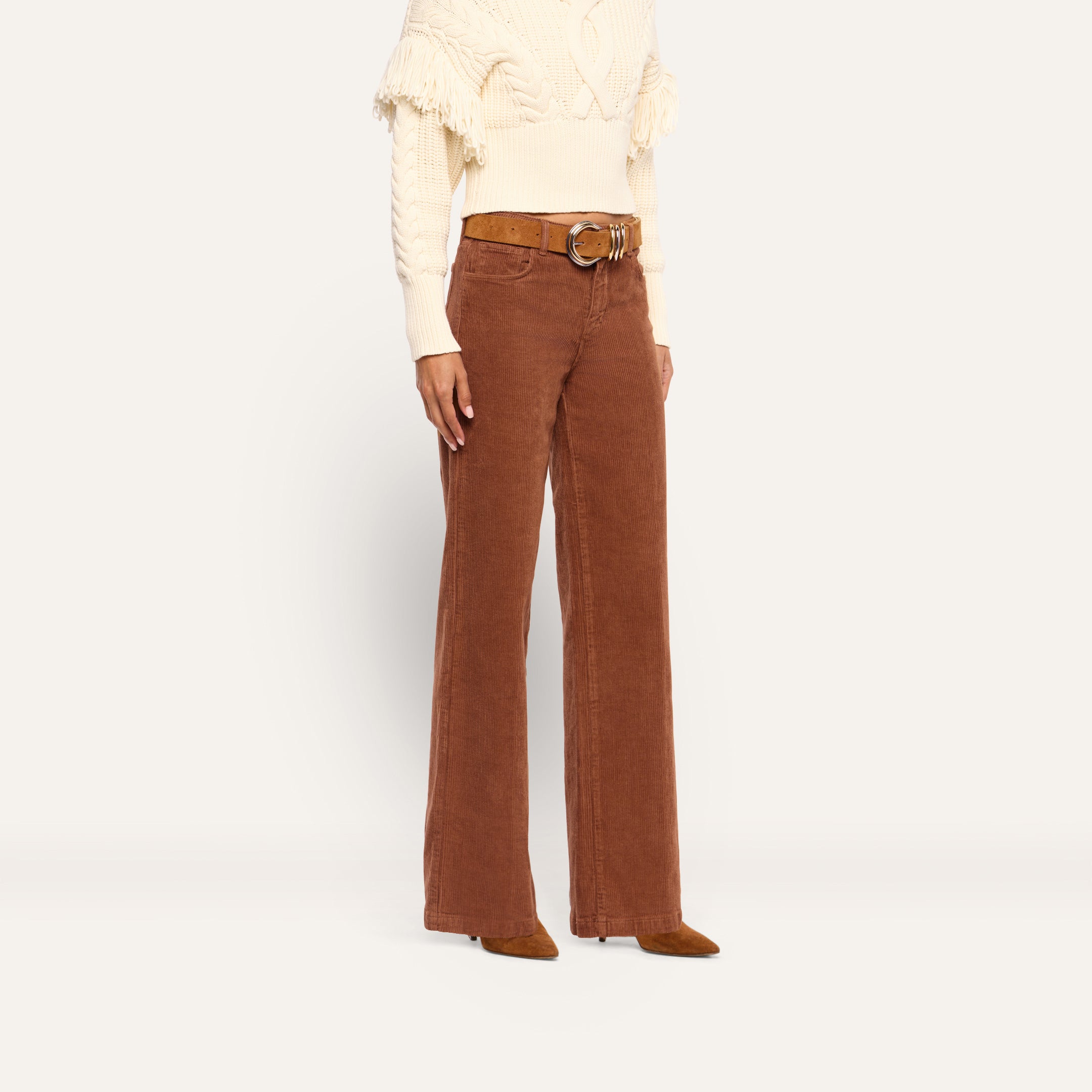 Person wearing cognac brown, high-rise, wide-leg Scottie Corduroy Wide-Leg Pant with a brown belt and a cream-colored fringe sweater.