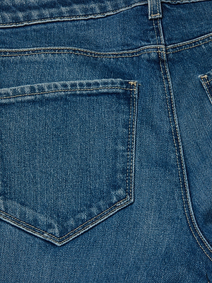 Close-up of the back pocket and waistband of the Cara Low-Rise Bootcut Jean by L'AGENCE, showcasing detailed stitching and textured blue stretch denim fabric.