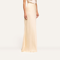 Wearing the Zeta Satin Maxi Skirt and a matching sleeveless top, the person stands against a plain, light background, shown from shoulders to feet.