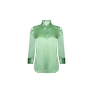 The Dani Silk Blouse is a light green, long-sleeve button-down top with a pointed collar and front buttons, crafted from luxurious silk charmeuse and shown against a white background.