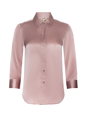 The Dani Silk Blouse is a womens long-sleeve, button-up blouse made of shiny pale pink silk with a pointed collar and cuffed sleeves.