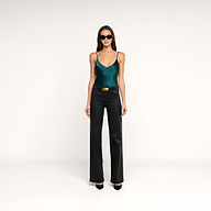 A woman wearing sunglasses, the Lexi Silk Camisole in teal with adjustable straps, black leather pants with a belt, and black heels stands against a plain white background.